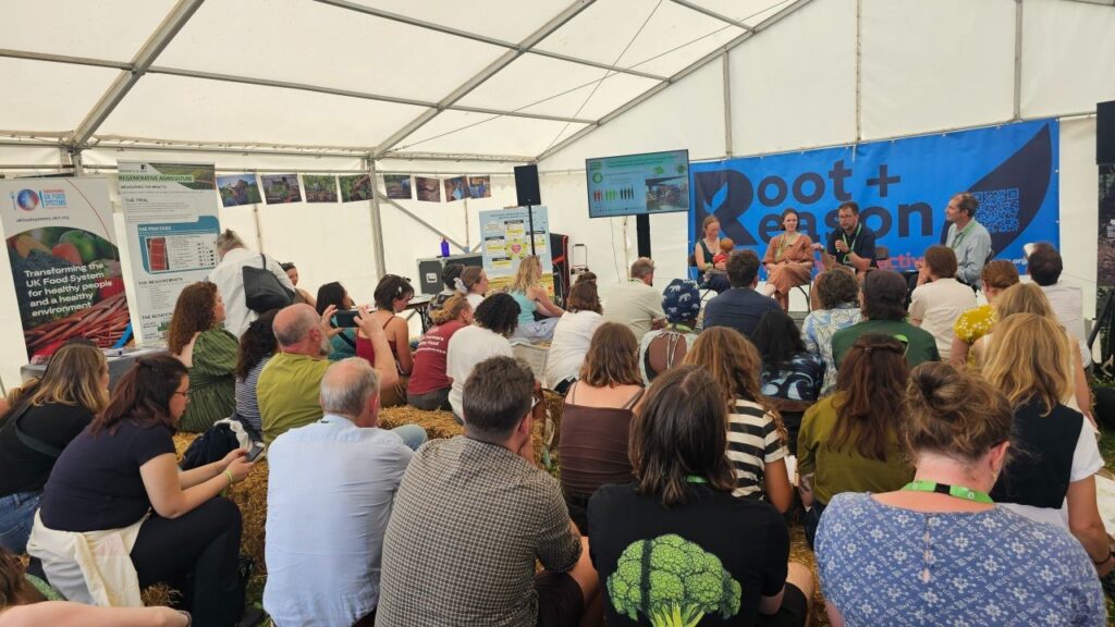 Audience watching a panel discussion inside a crowded marquee at Groundswell.